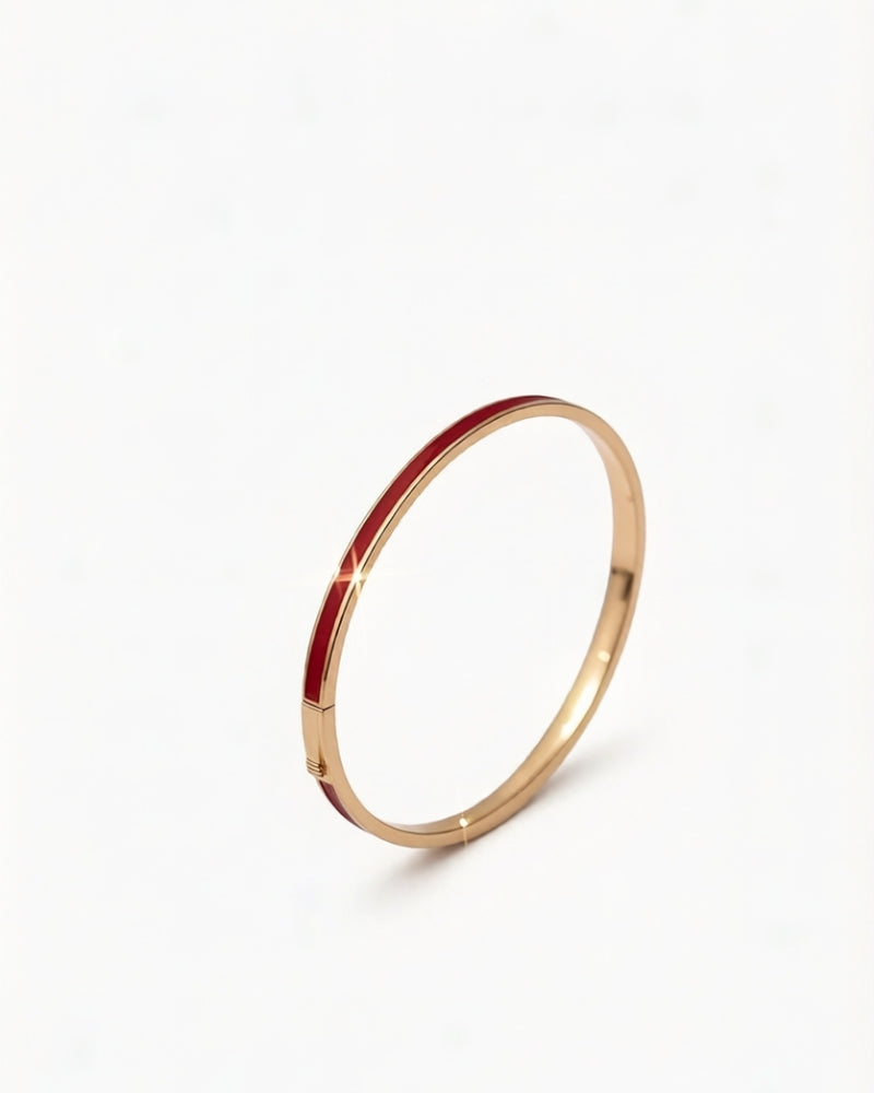 14K gold bangle with burgundy red enamel, shown on a soft neutral background