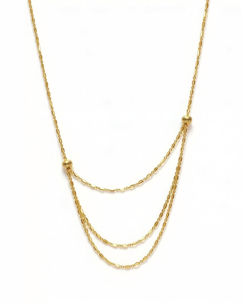 Adjustable triple-layer 18K gold necklace worn as layered strands
