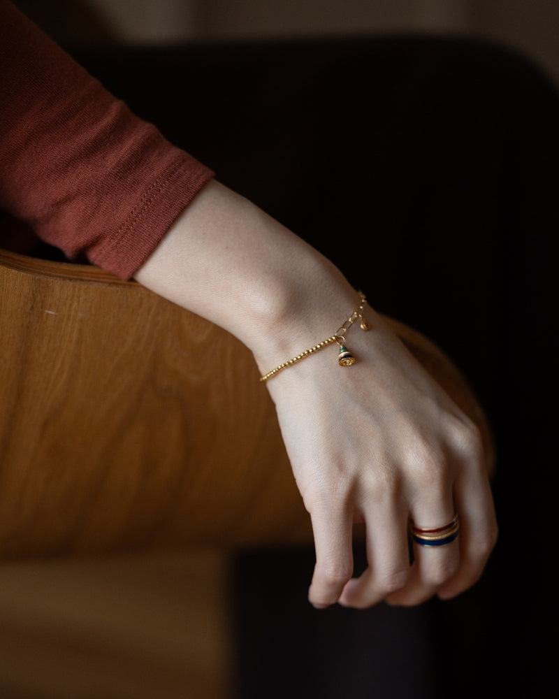 Joyous Bell 18K gold bead bracelet with a ten-color enamel bell, front view