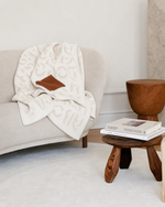 Oat cashmere blanket draped on modern sofa