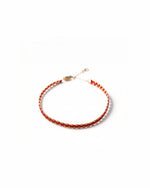 Adjustable red string bracelet with hand-stamped gold clasp and crimson silk detail, crafted from pure gold.