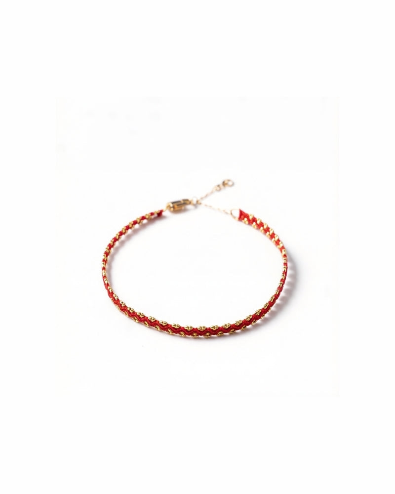 Adjustable red string bracelet with hand-stamped gold clasp and crimson silk detail, crafted from pure gold.