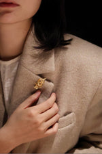 Model wearing Golden Parrot brooch on coat lapel, showcasing luxury styling-02